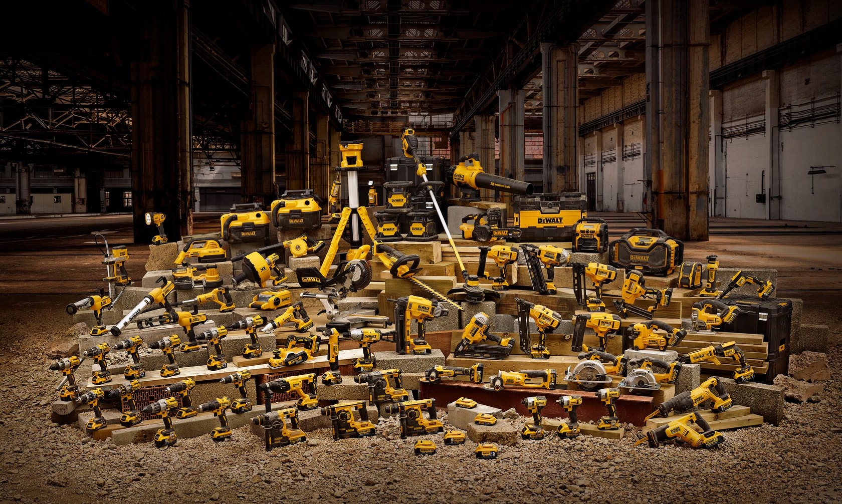 Verschiedene gelbe DEWALT Elektrowerkzeuge und Koffer in einem Industrie-Lager präsentiert.